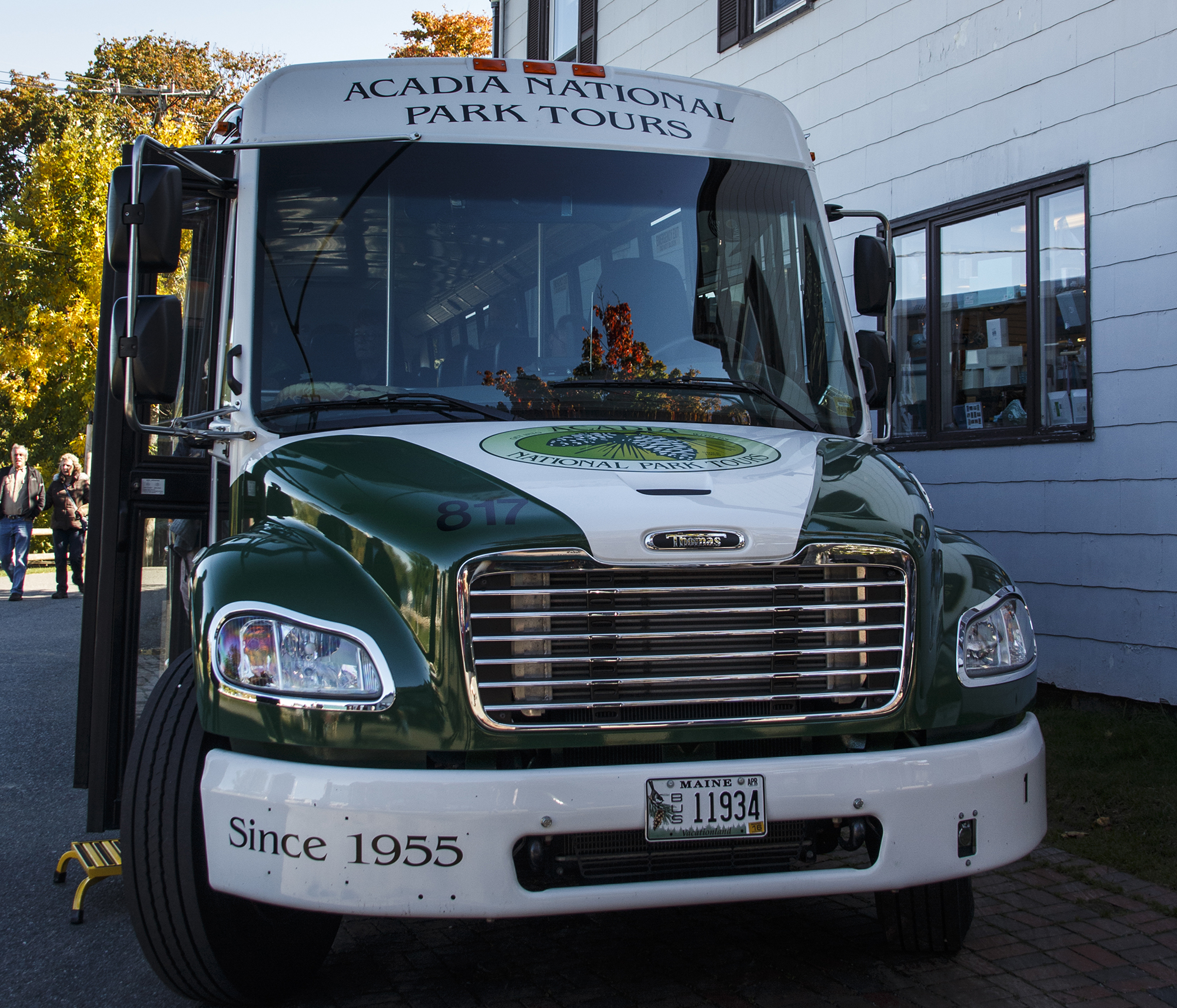a green and white bus with a logo on the front