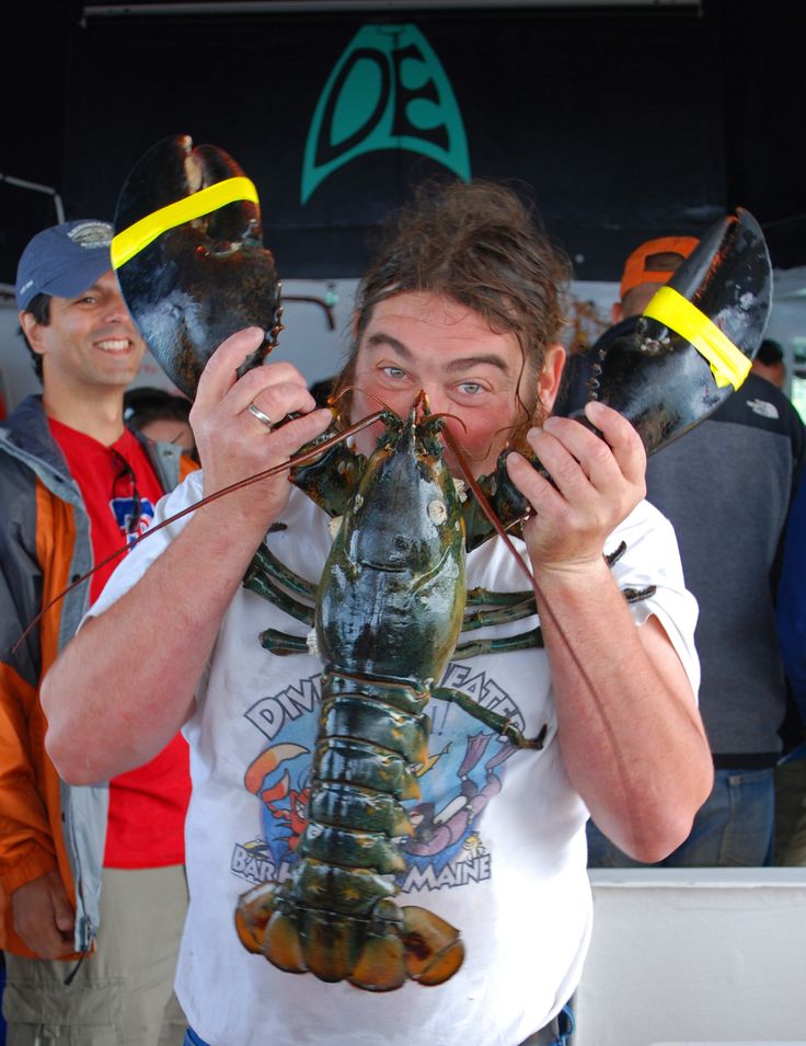 Photo of Diver Ed Monet holding a giant lobster infront of his face.