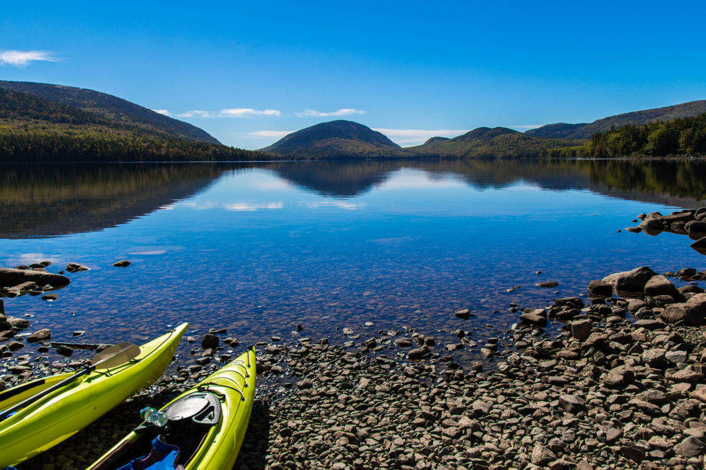 Scenic photo of two yellow kayaks along the shoreline of Jordan Pond, Acadia National Park